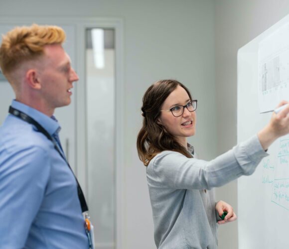 Man and woman in front of whiteboard